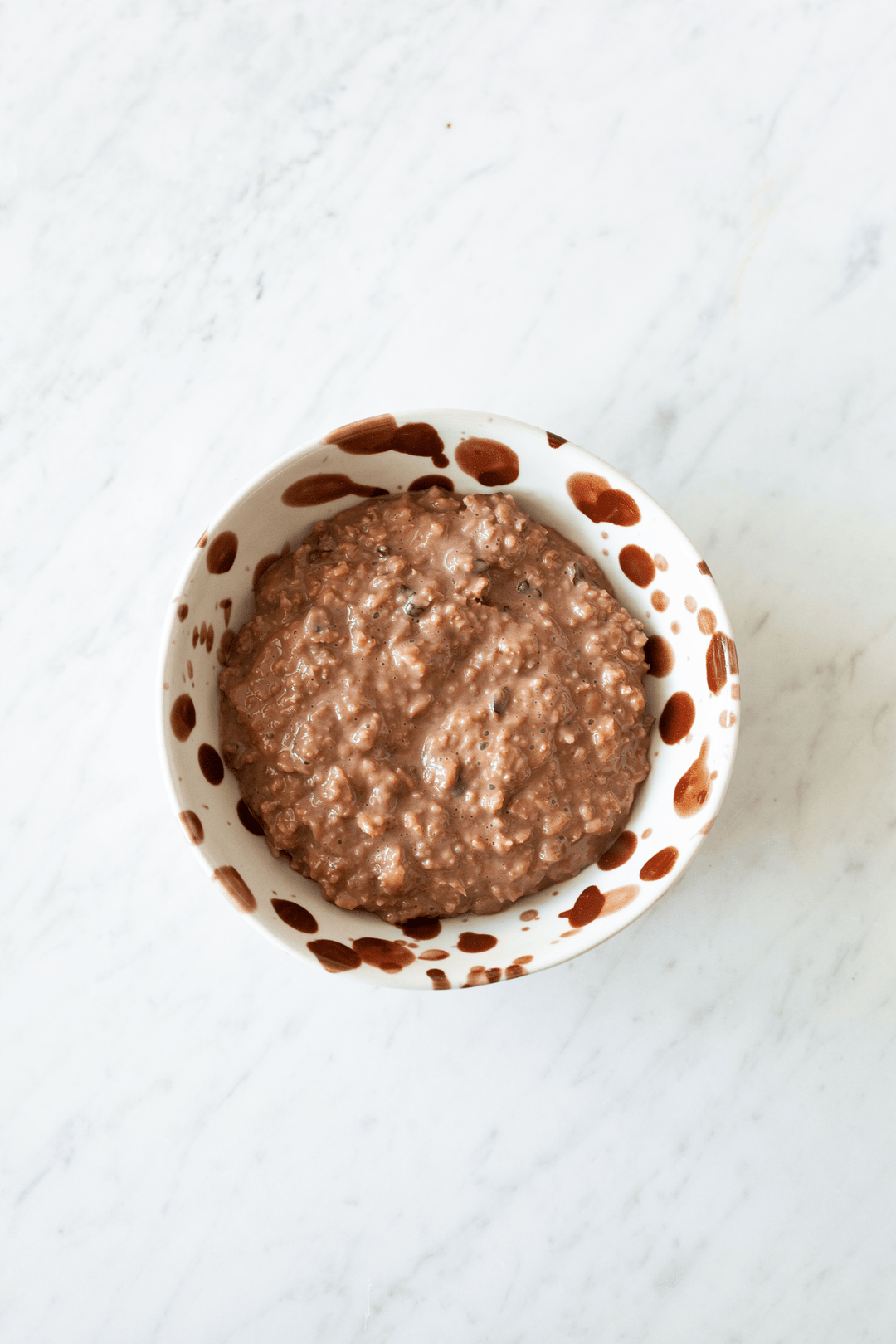Turtle Chocolate & Banana Porridge topped with fresh figs, a creamy topping, nuts-and-seeds granola and dark chocolate.